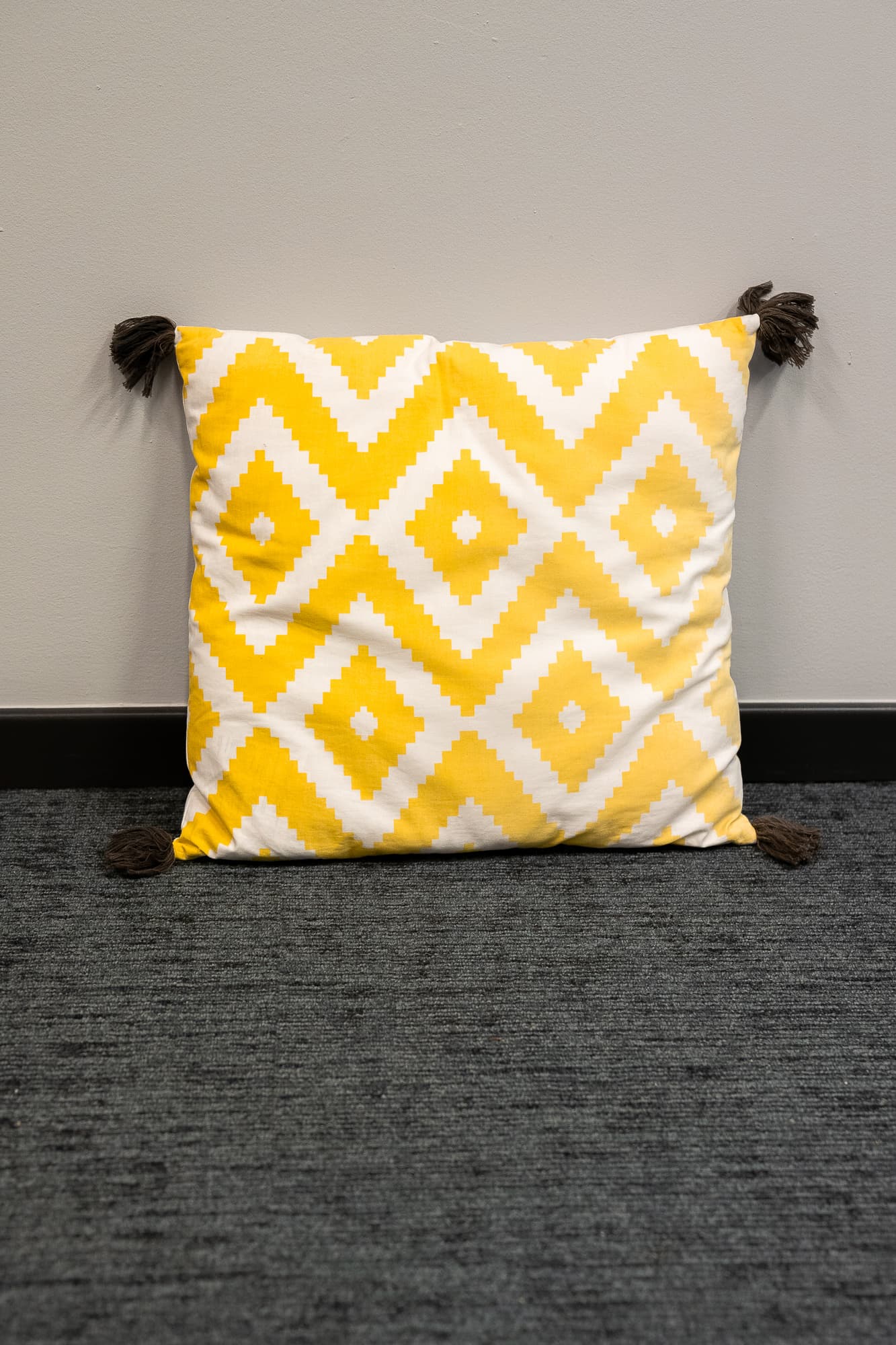 coussin blanc a motifs losanges jaune avec pompons-2